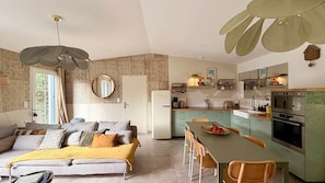 A modern kitchen with a dining area, a sofa, and a large mirror. - La Maison, ★ L'her beau d'hier 3-bedroom house (sleeps 8) 300m from the beach ★ (L'Épine)