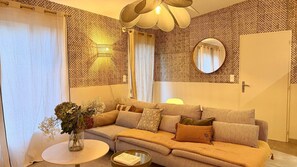 A cozy living room with a sofa, a round coffee table, and a decorative vase with flowers. - La Maison, ★ L'her beau d'hier Maison 3 chambres (8 couchages) à 300m de la plage ★ (L'Épine)