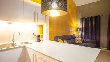 A modern kitchen with a white countertop, a built-in sink, and a pendant light.