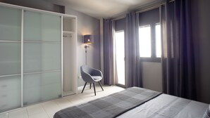 Une chambre moderne avec un lit, une chaise, une armoire et une fenêtre avec des rideaux.