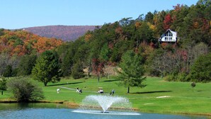 A golf course with a pond, a house on a hill, and autumn-colored trees. - 5 Free Daily Bryce Resort Passes!  Skiing, Tubing, Golf, Mountain Biking, Lake!  (Basye)