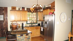 A kitchen with wooden cabinets, a granite countertop, a stainless steel refrigerator, and a stone backsplash. - 5 Free Daily Bryce Resort Passes!  Skiing, Tubing, Golf, Mountain Biking, Lake!  (Basye)