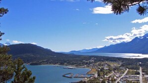A coastal town with a marina, surrounded by mountains and a large body of water.