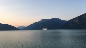 A cruise ship on a calm lake with mountains in the background.