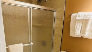 A bathroom with a glass-enclosed shower, a toilet, and a sink. - NC Music Factory Ranch Getaway (Charlotte)