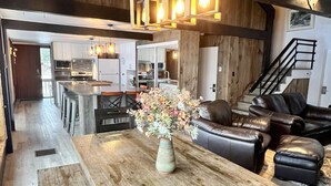 Eine geräumige Küche mit modernen Geräten, einem Holztisch und einem Blumenstrauß.