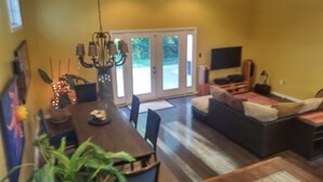 A dining area with a table and chairs, a chandelier, and a potted plant. - Large 3/4 bedroom Valley View House with Outdoor Space, Pool and Storm Shelter (Jonesboro)