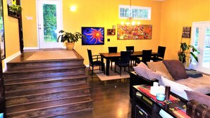 A dining area with a table and chairs, a sofa, and a coffee table with various items. - Large 3/4 bedroom Valley View House with Outdoor Space, Pool and Storm Shelter (Jonesboro)