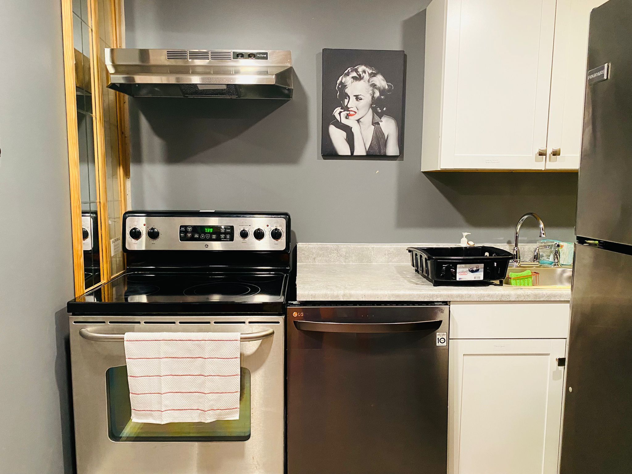 A kitchen with stainless steel appliances, a stove, oven, dishwasher, and a sink.