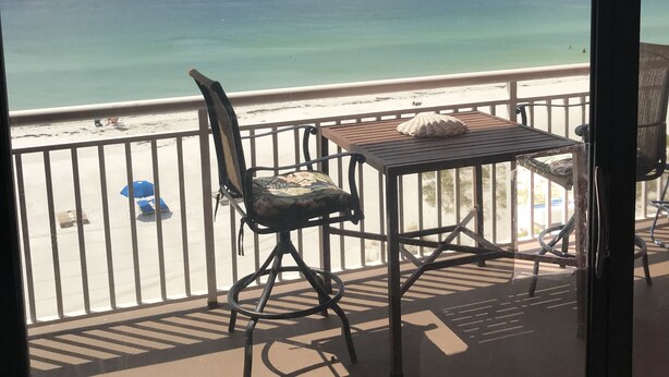 A balcony with a table, chairs, and a view of the ocean. - Chateaux #406  Charming Beachfront Retreat with spectacular views! (Indian Shores)