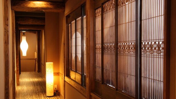Un pasillo tradicional con suelo de madera y puertas correderas con diseños elaborados.