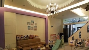 A spacious living room with a sofa, coffee table, and a chandelier. - Tongxinyu Homestay (Wujie)