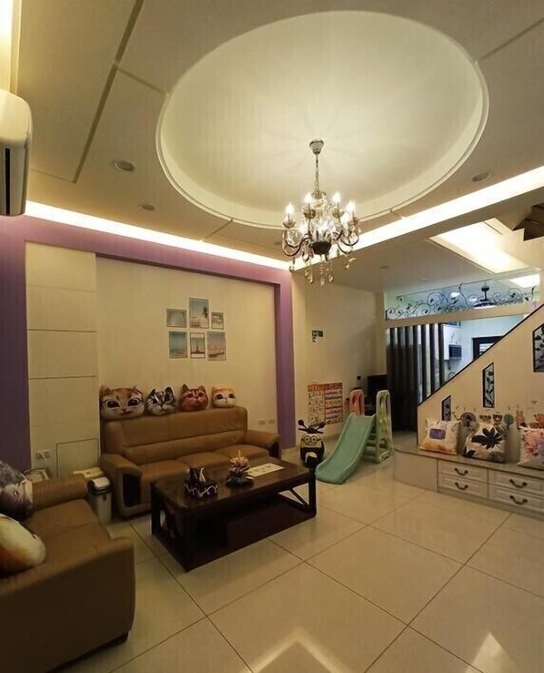 A spacious living room with a sofa, coffee table, and a chandelier. - Tongxinyu Homestay (Wujie)