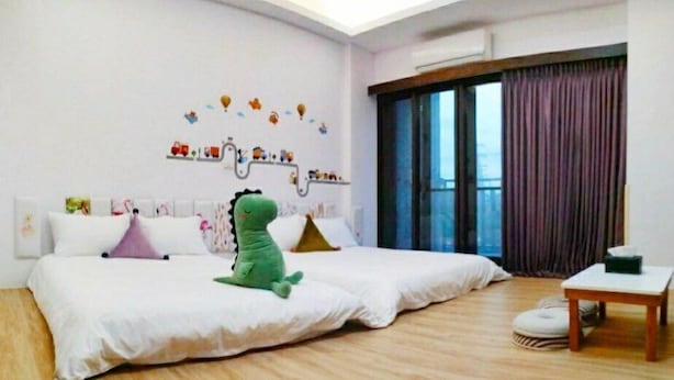 A spacious bedroom with a large bed, a small table, and a window with curtains. - Tongxinyu Homestay (Wujie)