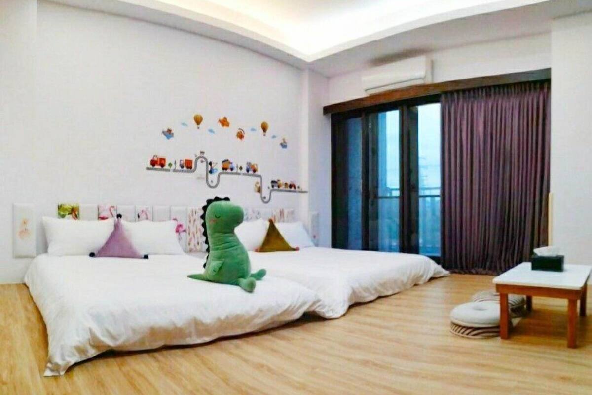 A spacious bedroom with a large bed, a small table, and a window with curtains.