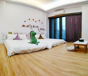 A spacious bedroom with a large bed, a small table, and a window with curtains. - Tongxinyu Homestay (Wujie)