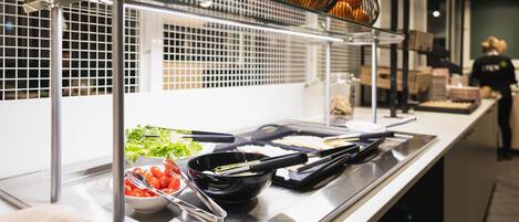 Una mesa de buffet con diferentes alimentos y utensilios.