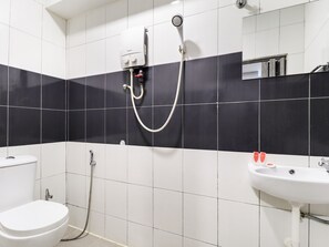 A bathroom with a toilet, a sink, a shower, and a mirror. - OYO 89381 Moonnight Hotel (Batu Caves)