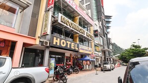 A hotel with a prominent sign, a visible entrance, and parked motorcycles. - OYO 89381 Moonnight Hotel (Batu Caves)
