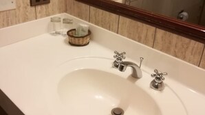 A bathroom with a large mirror, a white sink, and a small wicker basket on the countertop. - WHITE HOUSE MACHUPICCHU (Pueb Machu Picchu)