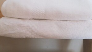 A white, plush, rectangular object with a textured surface, possibly a cushion or a piece of furniture, placed on a flat surface. - WHITE HOUSE MACHUPICCHU (Pueb Machu Picchu)