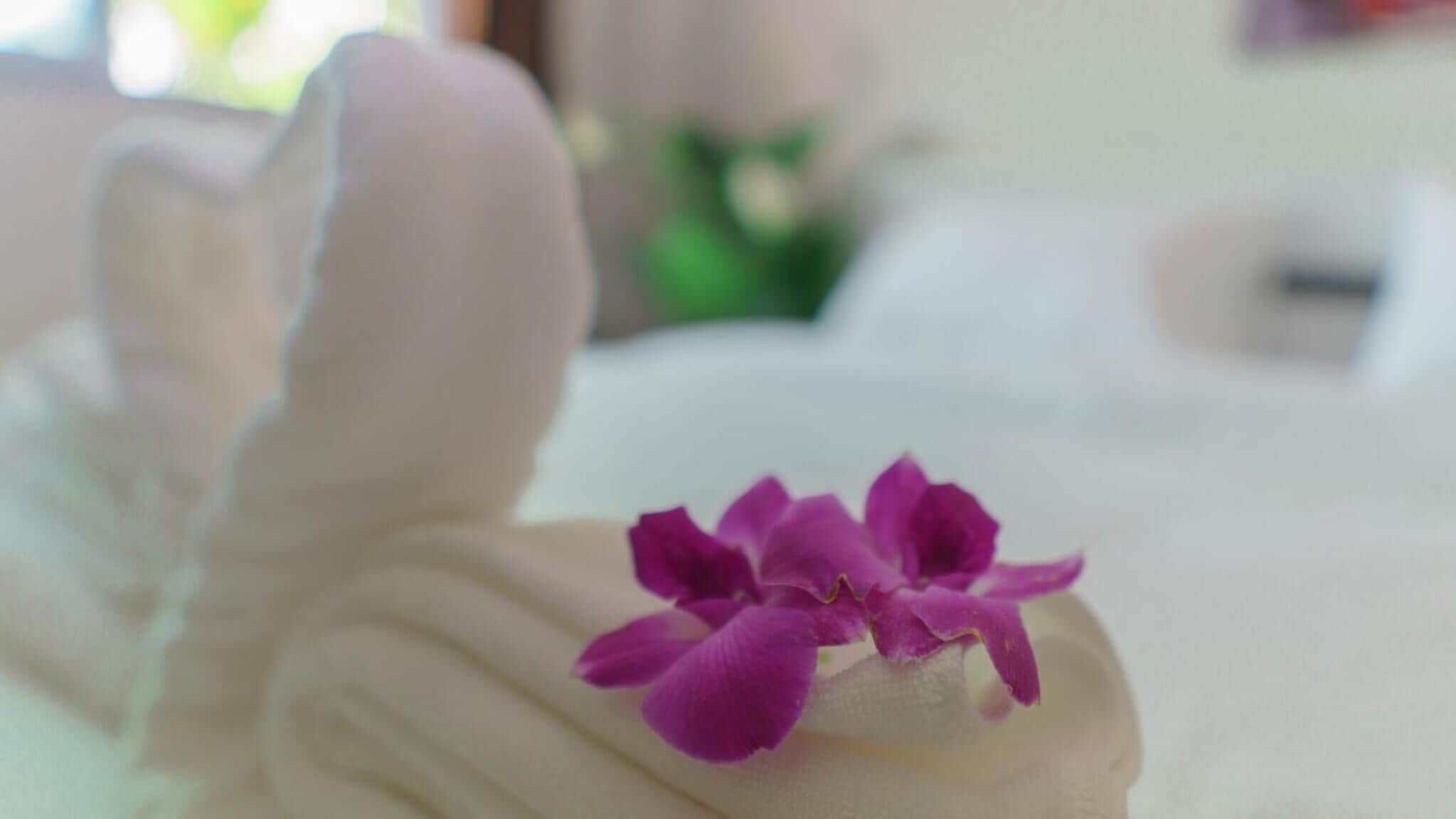 A white statue with a purple flower on top.