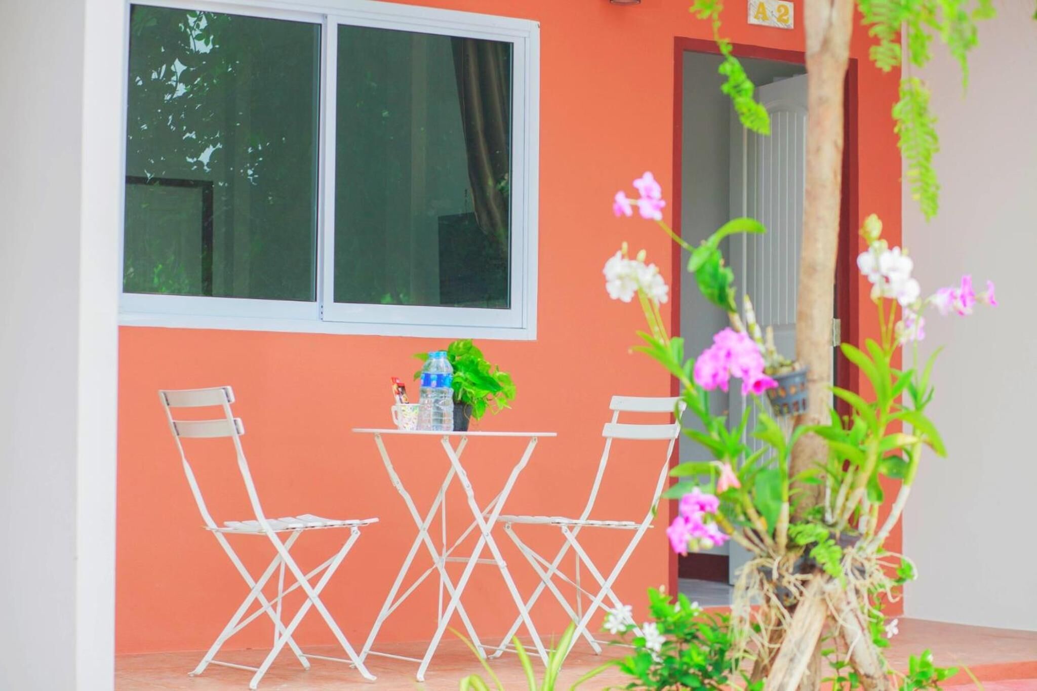 A room with a window, a table with chairs, and a potted plant.