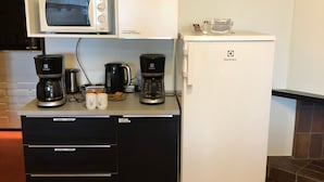 A compact kitchenette with a microwave, coffee maker, and a refrigerator. - Hotelli Äänekoski (Äänekoski)