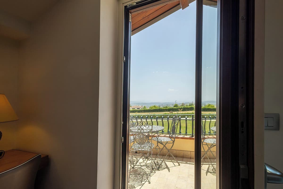 Un balcon aménagé avec du mobilier d’extérieur et offrant une vue sur la campagne.