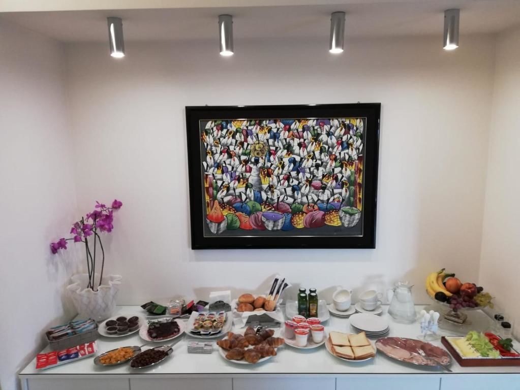 Un buffet proposant une variété de plats et une grande œuvre d’art encadrée accrochée au mur.