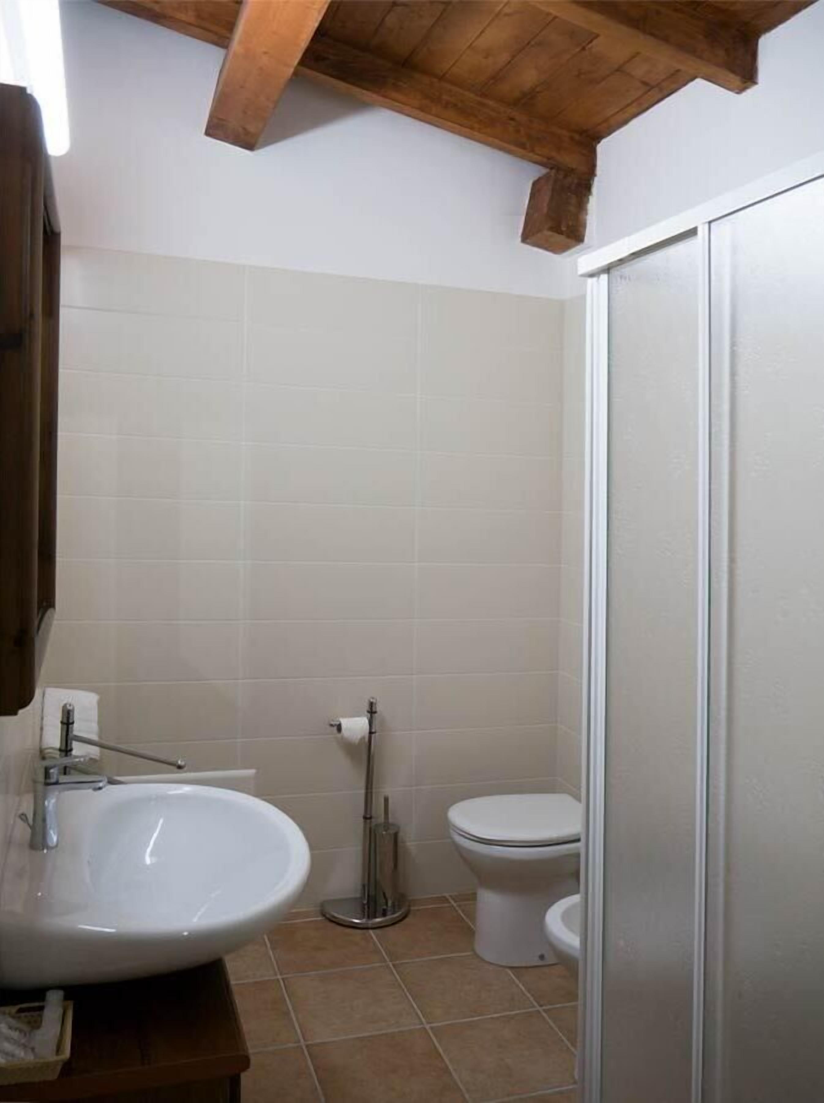 Une salle de bain avec un lavabo, des toilettes et un miroir.