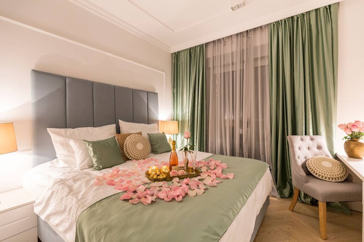 A neatly arranged bedroom with a bed, bedside tables, and a chair.