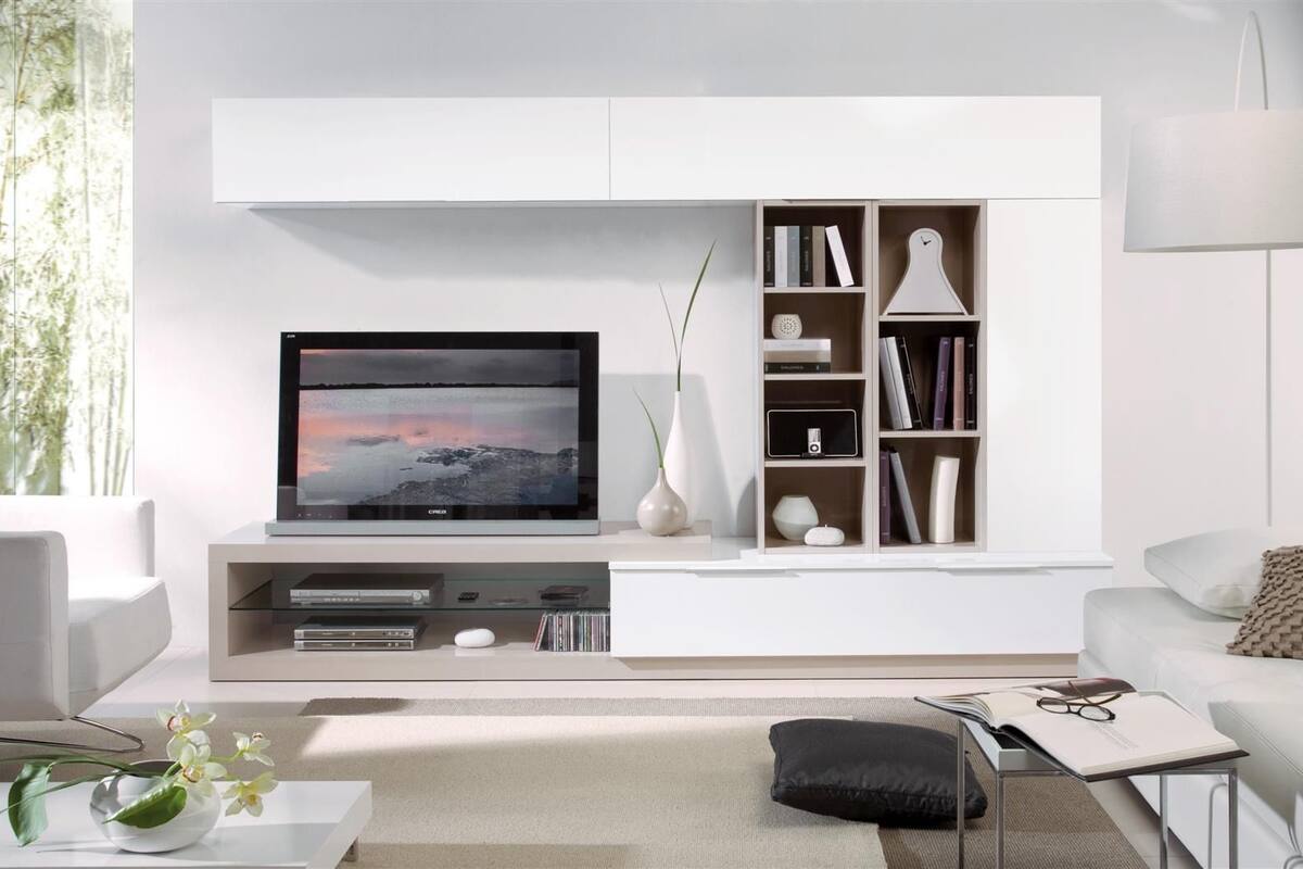 A modern living room with a flat-screen TV, a bookshelf, and a white sofa.