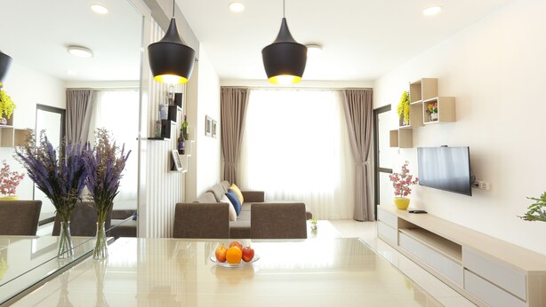 A modern living room with a glass dining table, two sofas, a TV, and pendant lights. - Ami Splendid Rooftop Garden (Ho Chi Minh City)