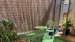 A small outdoor seating area with a wooden bench and two green chairs. - Private access, remote gate.  Netflix,  Foxtel,  Wi-Fi,  A/C, (Broken Hill)