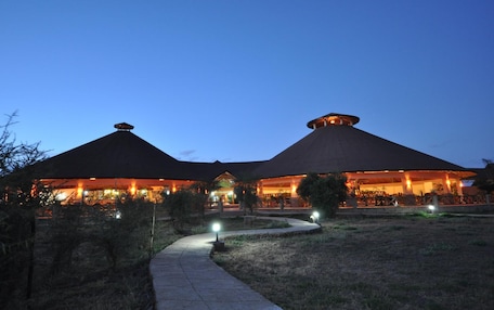 A building with a thatched roof and a paved pathway leading to it.