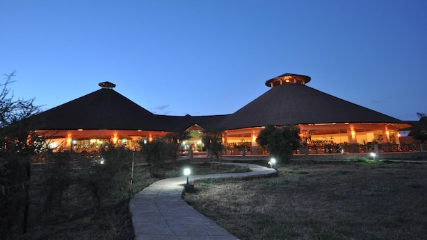 A building with a thatched roof and a paved pathway leading to it.