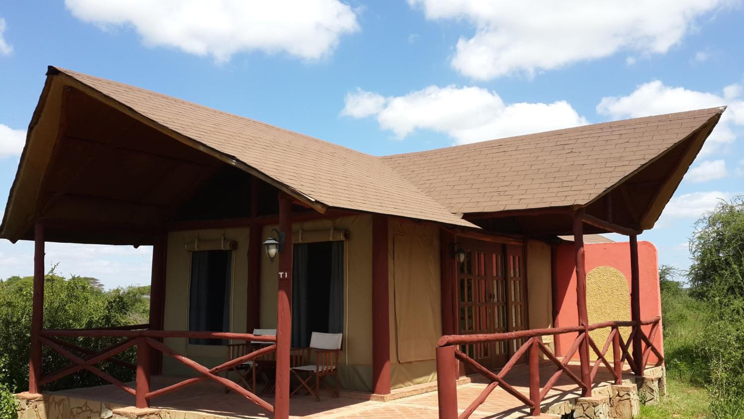 A two-story building with a flat roof and a covered porch.