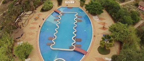 Una piscina octagonal con una isla central y sillones de descanso alrededor.