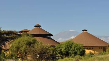 A series of conical-roofed buildings with a mountain in the background.