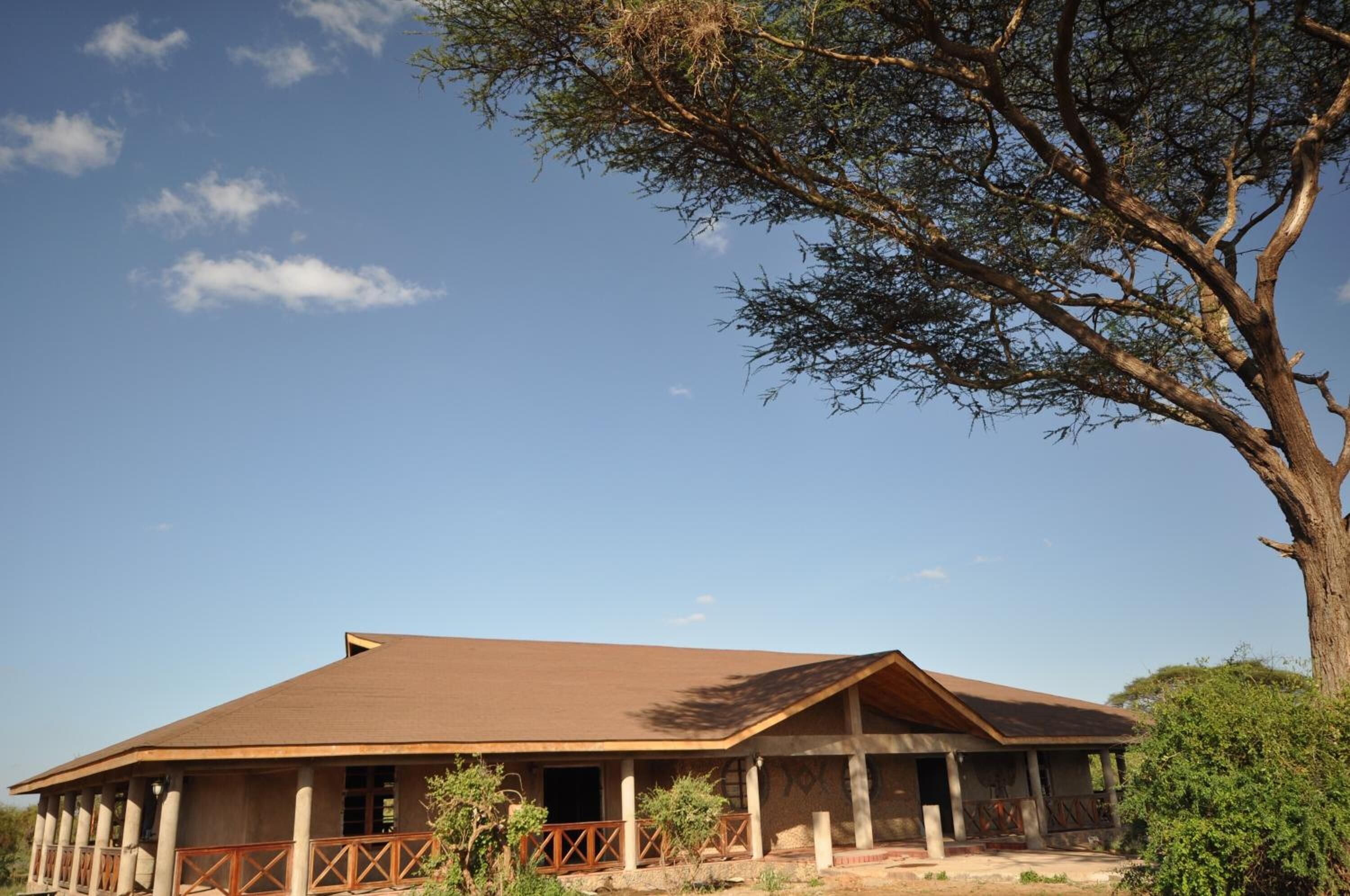 A large, single-story building with a flat roof and a covered porch.