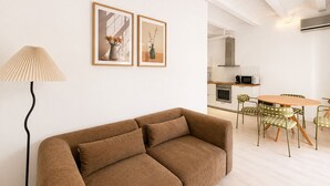 Ein modernes Wohnzimmer mit einer Couch, einer Lampe und einem Essbereich mit Stühlen und einem Tisch.