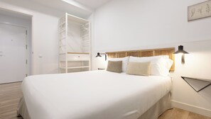 Ein Schlafzimmer mit einem großen Bett, einem eingebauten Kleiderschrank und einem Nachttisch mit einer Lampe.