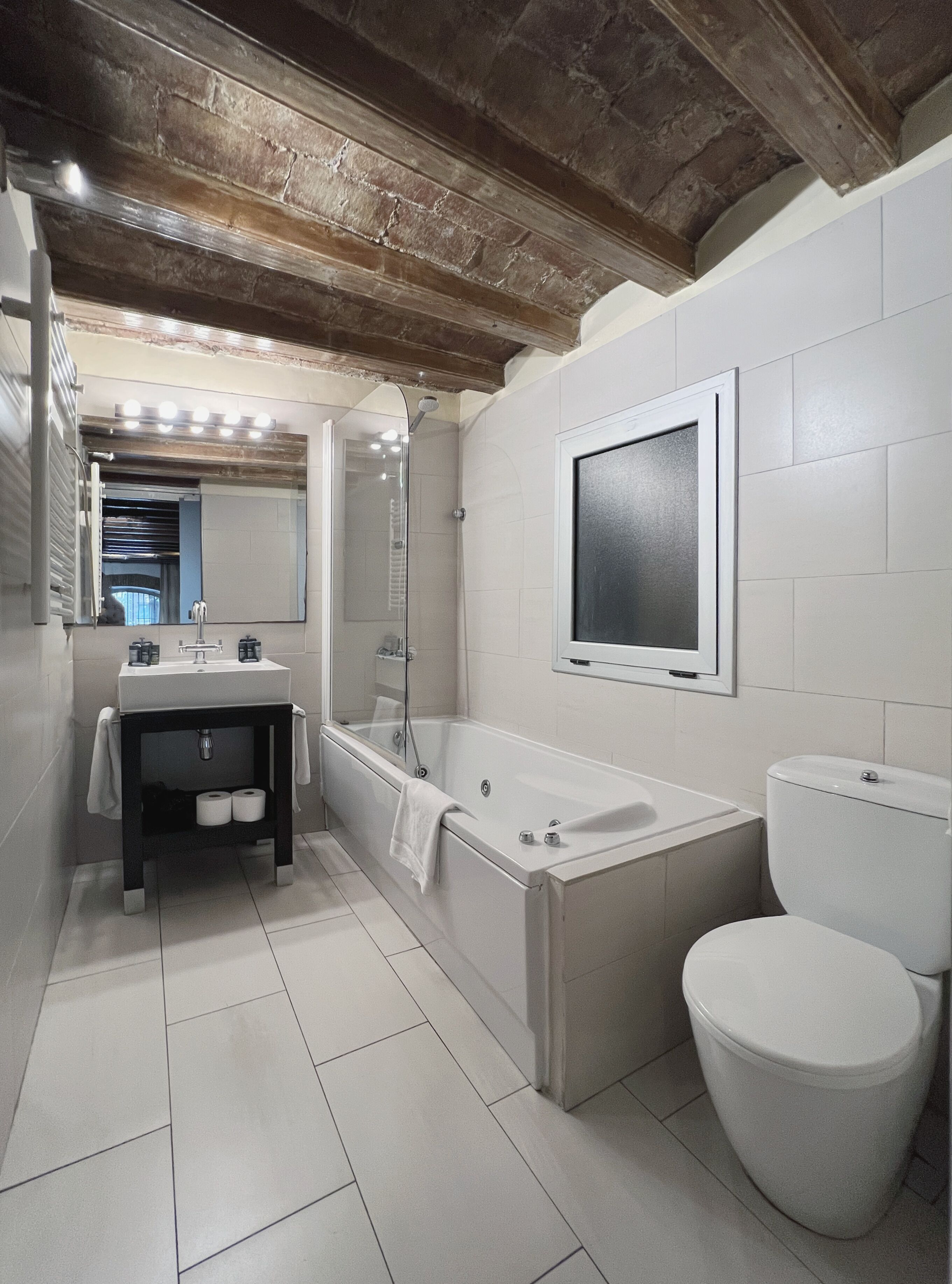 A modern bathroom with a bathtub, toilet, and sink.