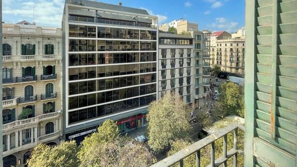 A modern building with multiple floors, large windows, and a mix of architectural styles. - Stay U-nique Apartments Plaça Universitat (Barcelona)