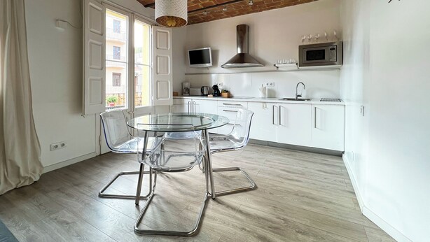A modern kitchen with white cabinets, a stainless steel range hood, and a built-in microwave. - Stay U-nique Apartments Fontrodona (Barcelona)