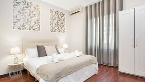 A hotel room with a bed, two bedside tables, a wardrobe, and a large window with curtains. - Stay U-nique Apartments Calvet (Barcelona)