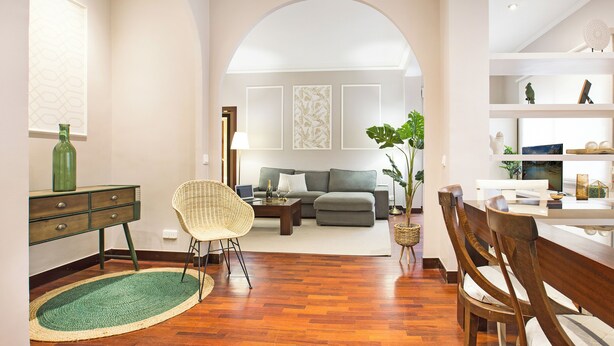 A spacious living room with a sofa, chairs, a coffee table, and a dining area with a table and chairs. - Stay U-nique Apartments Calvet (Barcelona)