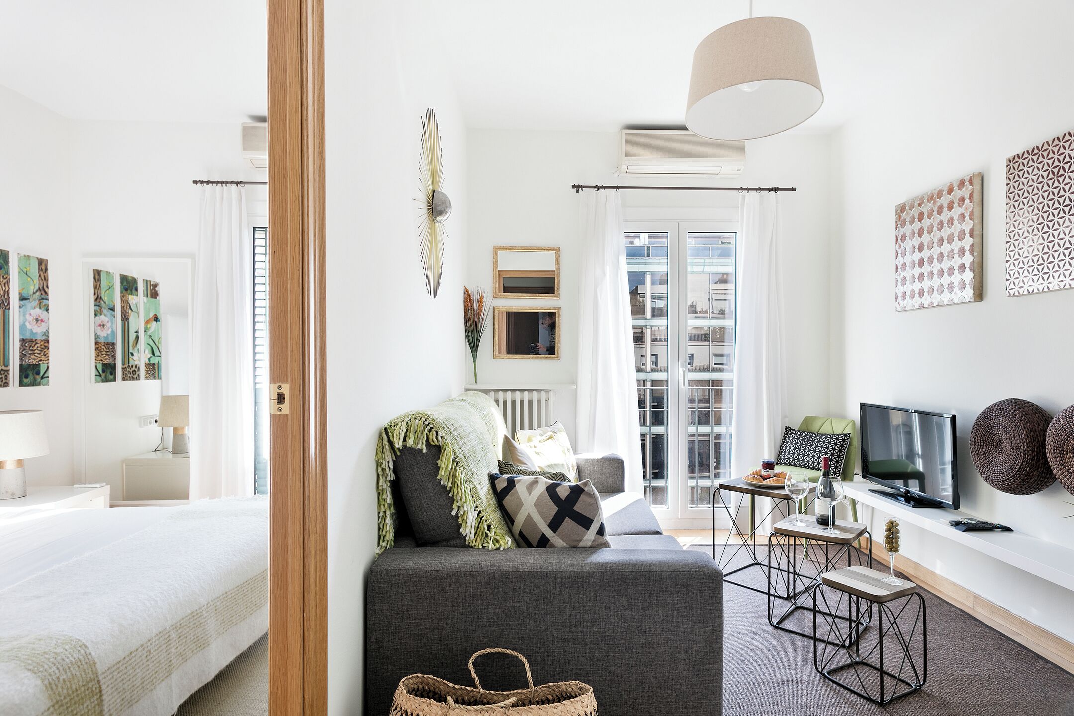 A modern living room with a sofa, a TV, and a dining area.