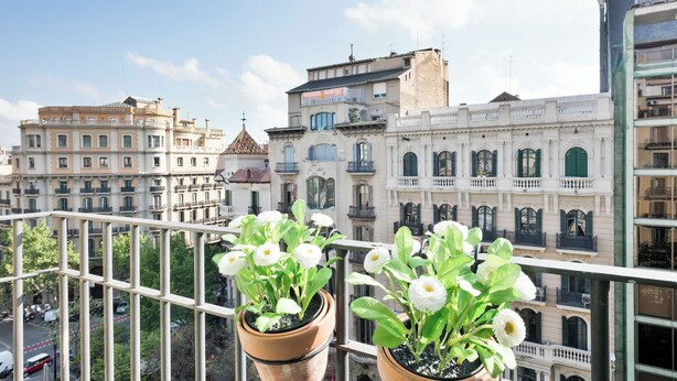 A balcony with potted plants and a view of historic buildings. - Stay U-nique Apartments Rambla Catalunya (Barcelona)